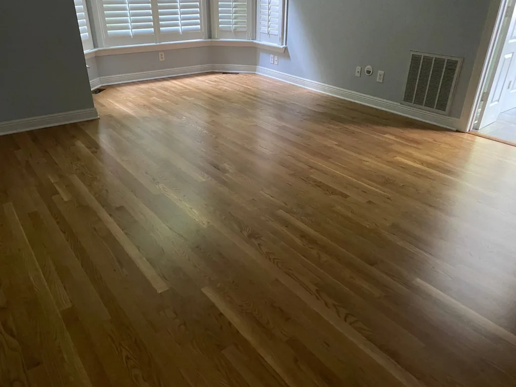 Medium-brown hardwood floor in a room with a curved architectural nook